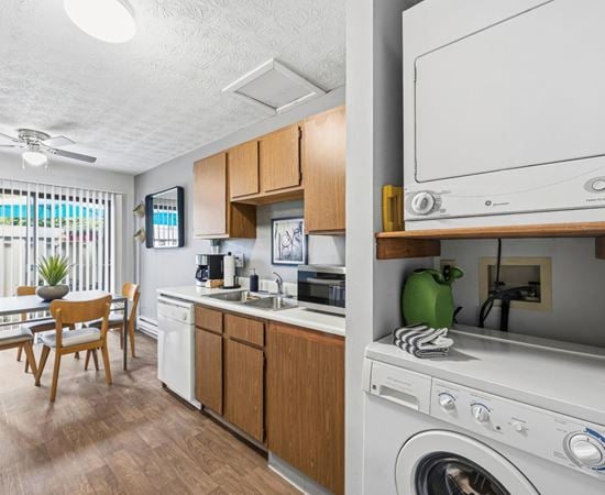 A small kitchen with a washing machine on top of the counter.